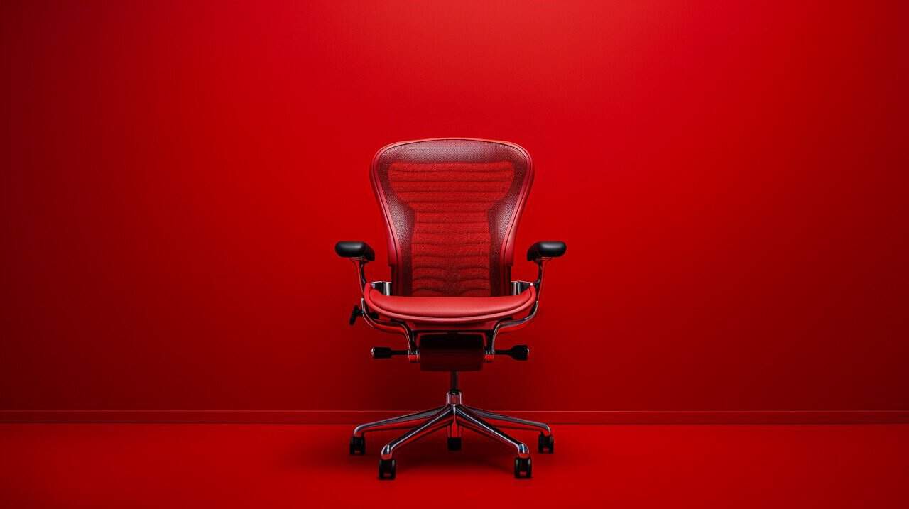 herman miller office chair photograph in a red studio
